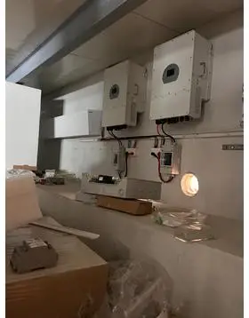 Dwa inwertery instalacji solarnych zamontowane na ścianie z kablami i osprzętem